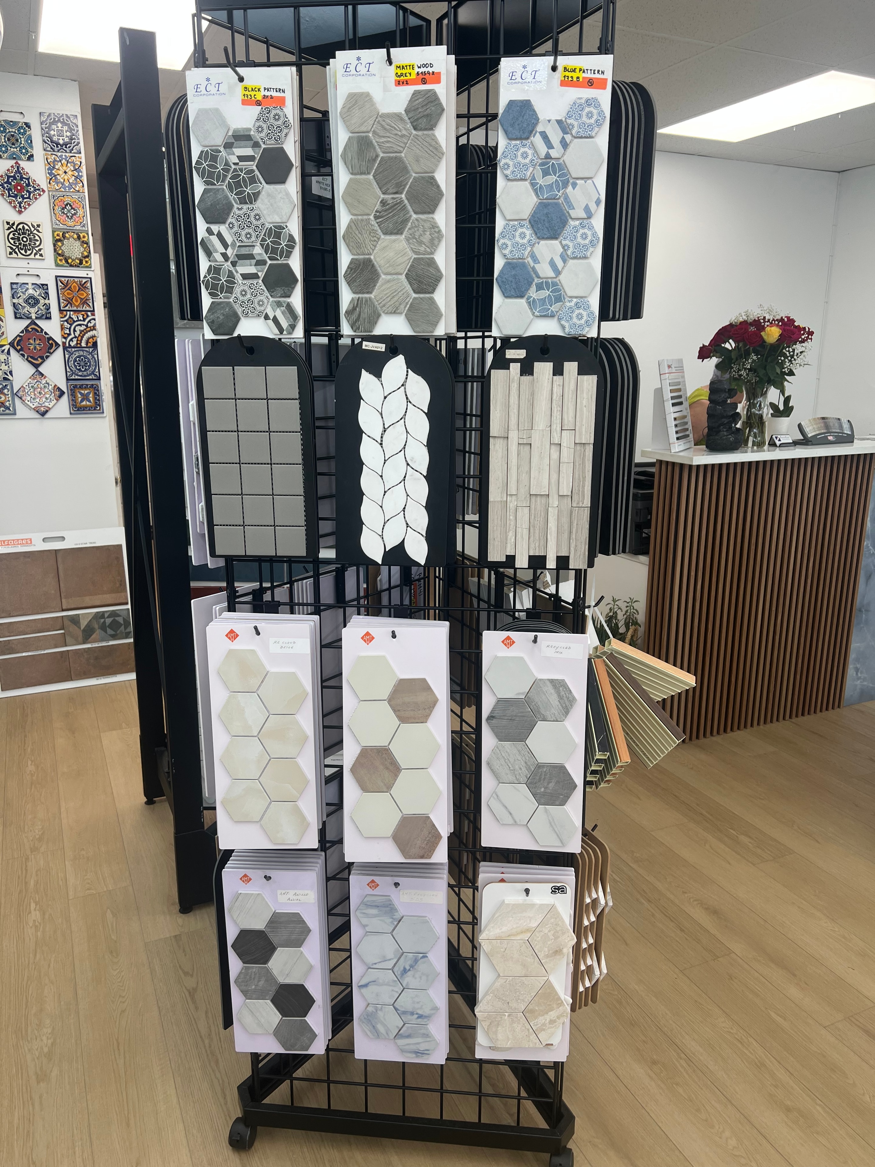 Rack del showroom con mosaicos hexagonales en tonos grises, beige y azul con patrones decorativos ECT