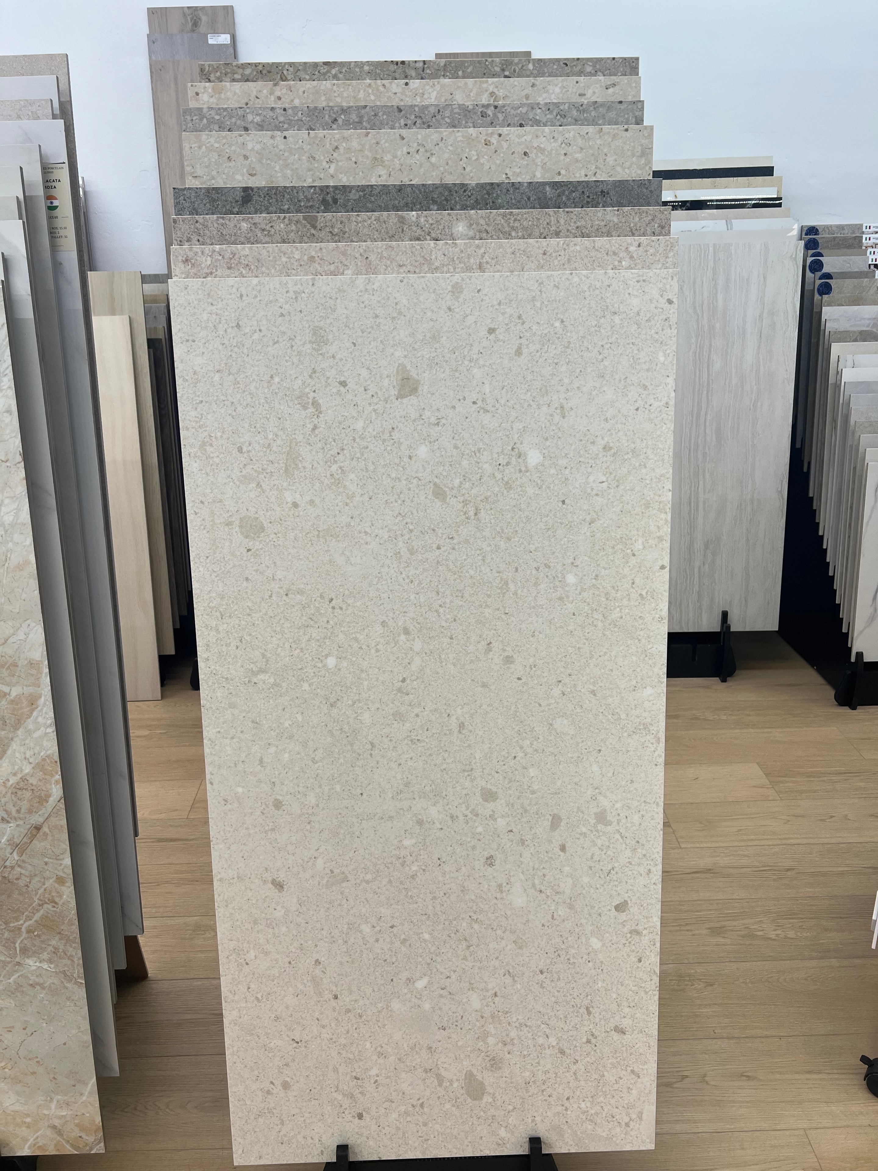 Large-format cream terrazzo porcelain tile samples in showroom display